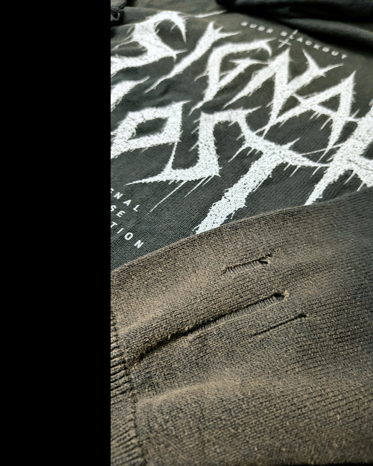 BLACKOUT distressed full zip Sweater – Detail: exakt gesetzte Destroyed-Stelle im Strick