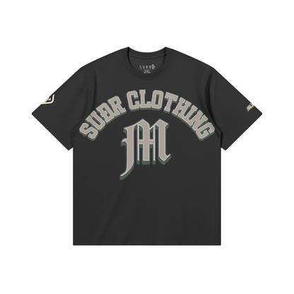 SUÐR M Shirt – Shirt in Black, Vorderseite mit SUÐR CLOTHING im Bogen, darunter das M in Blackletter, Emblem und SUÐR-Schriftzug auf den Ärmeln, liegend