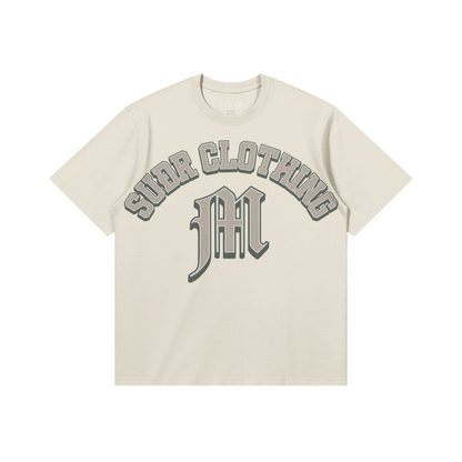 SUÐR M Shirt – Shirt in Pale Oak, Vorderseite mit SUÐR CLOTHING im Bogen, darunter das M in Blackletter, Emblem und SUÐR-Schriftzug auf den Ärmeln, liegend