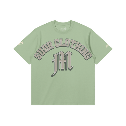 SUÐR M Shirt – Shirt in Light Mint, Vorderseite mit SUÐR CLOTHING im Bogen, darunter das M in Blackletter, Emblem und SUÐR-Schriftzug auf den Ärmeln, liegend