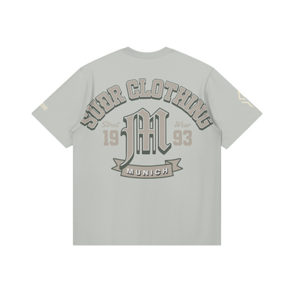 SUÐR M Shirt – Shirt in Light Gray, Rückseite mit SUÐR CLOTHING im Bogen, das M in Blackletter, dazu „Street Wear", „19 93" und das MUNICH-Banner, liegend