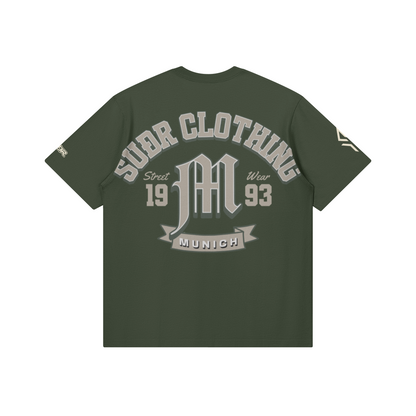 SUÐR M Shirt – Shirt in Charcoal Smoke, Rückseite mit SUÐR CLOTHING im Bogen, das M in Blackletter, dazu „Street Wear", „19 93" und das MUNICH-Banner, liegend