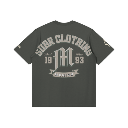 SUÐR M Shirt – Shirt in Carbon Gray, Rückseite mit SUÐR CLOTHING im Bogen, das M in Blackletter, dazu „Street Wear", „19 93" und das MUNICH-Banner, liegend