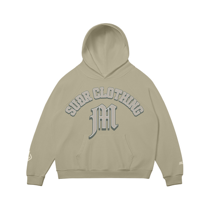 SUÐR M Hoodie – Hoodie in Camel, Vorderseite mit SUÐR CLOTHING im Bogen, darunter das M in Blackletter über der Kängurutasche, Emblem und SUÐR-Schriftzug auf den Ärmeln, liegend