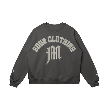 SUÐR M Sweatshirt – Sweatshirt in Charcoal Gray, Vorderseite mit SUÐR CLOTHING im Bogen, darunter das M in Blackletter, Emblem und SUÐR-Schriftzug auf den Ärmeln, liegend